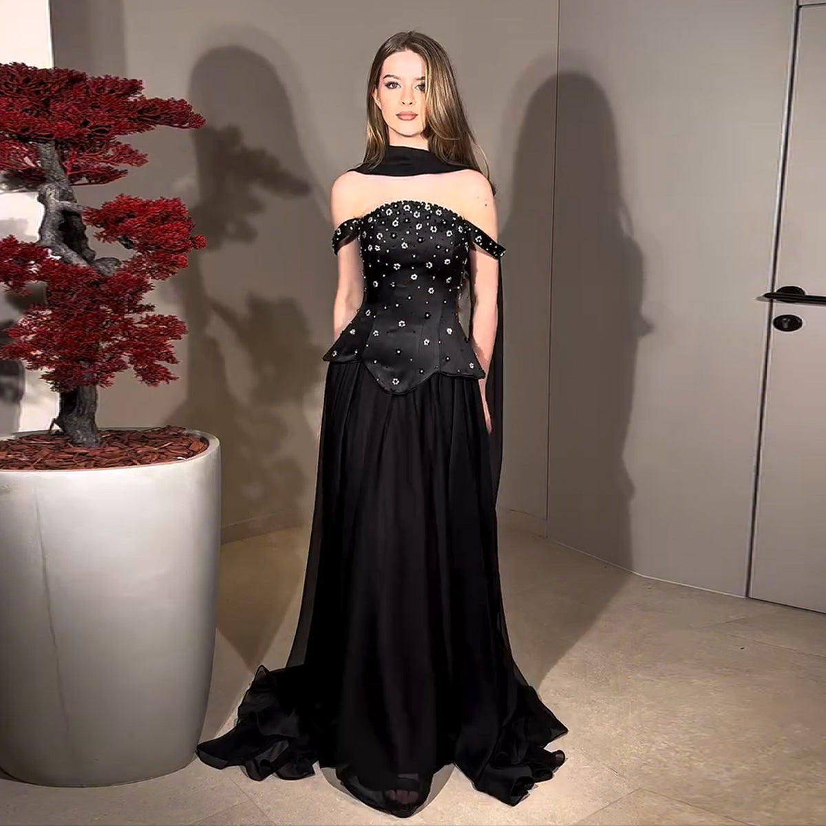 luxury handle dress Where modern allure meets sculptural grace. The Dora Dress traces the body with a fluid, elongated silhouette, while the softly draped cape layer creates an ethereal sense of movement with every step